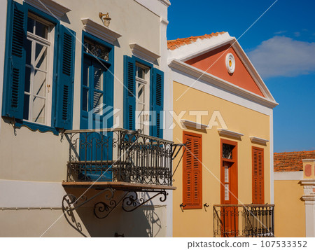 Cute details of windows, doors, balconies from old house in Simi island . Greece islands holidays from Rhodos in Aegean Sea. Colorful neoclassical houses in bay of Symi. Holiday travel background. Cute details of windows, doors, balconies from old house in Simi island . Greece islands holidays from Rhodos in Aegean Sea. Colorful neoclassical houses in bay of Symi. Holiday travel background. 107533352