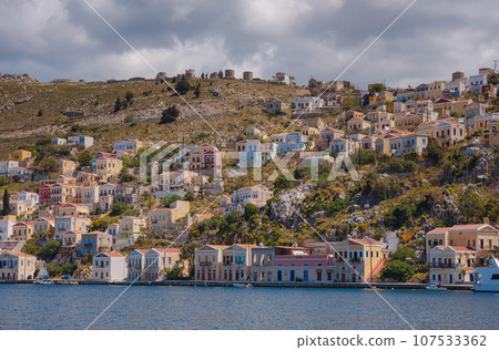 Symi Island, Greece. Greece islands holidays from Rhodos in Aegean Sea. Colorful neoclassical houses in bay of Symi. Holiday travel background. 107533362