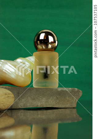 Makeup product, pearl seashell on emerald green background. Stylish beauty blog. Moisturizing serum for face body skin care. Essential oil flacon, perfume bottle. Luxury rich cosmetic on stone podium. Makeup product, pearl seashell on emerald green background. Stylish beauty blog. Moisturizing serum for face body skin care. Essential oil flacon, perfume bottle. Luxury rich cosmetic on stone podium. 107537105