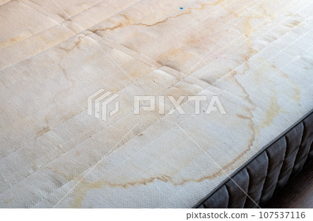 Stains and dirt on the mattress background. Close-up view on it 107537116