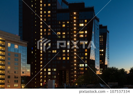 Night architecture. Skyscrapers with glass facade. Modern house building in the sunset light 107537334