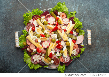 Fiambre, salad of Guatemala, Mexico and Latin America, served on large plate top view. Festive dish for All Saints Day (Day Of The Dead) celebration made of cold cuts, sausages, pickled vegetables 107537393