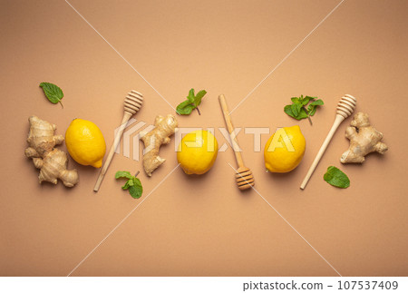 Composition with lemons, mint, ginger top view on simple beige background. Food for immunity stimulation and against seasonal flu. Healthy natural remedies to boost immune system 107537409