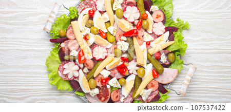 Fiambre, salad of Guatemala, Mexico and Latin America, on large plate top view white wooden background top view. Festive dish for All Saints Day (Day Of The Dead) celebration Fiambre, salad of Guatemala, Mexico and Latin America, on large plate top view white wooden background top view. Festive dish for All Saints Day (Day Of The Dead) celebration 107537422