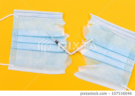 Broken Medical Syringe and Torn Medical Face Mask Broken Medical Syringe and Torn Medical Face Mask 107538046