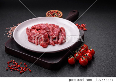 Fresh juicy raw beef slices with salt and spices 107538275