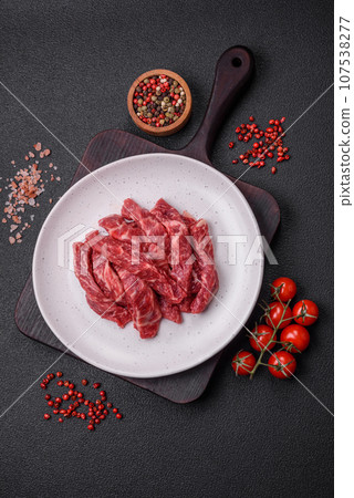 Fresh juicy raw beef slices with salt and spices 107538277
