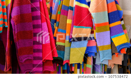 Assorted colors of woolen knitted off the shoulder clothes at the market of clothing homemakers. Selective focus. 107538472