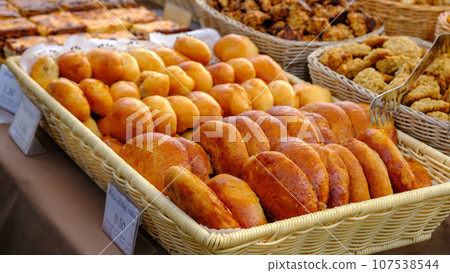 Many freshly baked buns in the basket. Top view bread. Pies freshly baked at the home producers' market Many freshly baked buns in the basket. Top view bread. Pies freshly baked at the home producers' market 107538544
