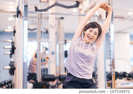 Middle-aged woman stretching at the gym Middle-aged woman stretching at the gym 107538972