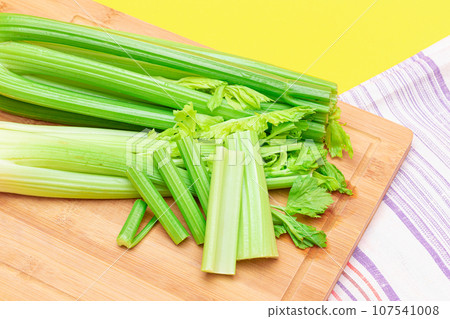 Fresh Celery Stem and Chopped Celery Sticks on Wooden Cutting Board Fresh Celery Stem and Chopped Celery Sticks on Wooden Cutting Board 107541008