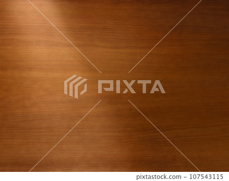 Background image of a delicate brown wooden desk top with light shining diagonally from the upper left Background image of a delicate brown wooden desk top with light shining diagonally from the upper left 107543115