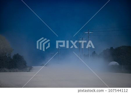 Dust on a gravel road after a vehicle passed 107544112