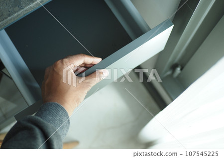 top view of men hand open a a drawer top view of men hand open a a drawer 107545225