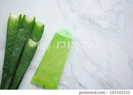 Fresh aloe vera sliced and liquid gel in plastic container on white background  107545233