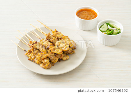 Pork satay with peanut sauce pickles which are cucumber slices and onions in vinegar Pork satay with peanut sauce pickles which are cucumber slices and onions in vinegar 107546392