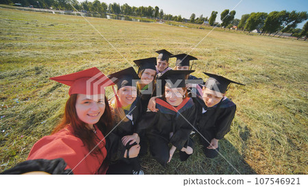 College alumni take selfies in the meadow. College alumni take selfies in the meadow. 107546921