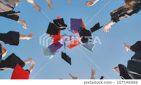 College graduates throw colorful hats up in the air. College graduates throw colorful hats up in the air. 107546988