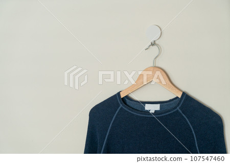 navy sweater hanging with wood hanger 107547460