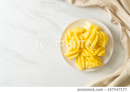 fresh pineapple sliced on plate 107547577