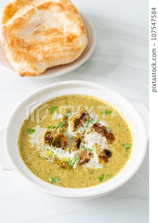 Afghani chicken in green masala curry or Hariyali tikka chicken hara masala with roti or naan bread 107547584