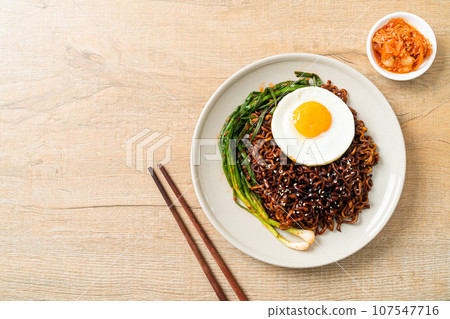 dried Korean spicy black sauce instant noodles with fried egg and kimchi 107547716