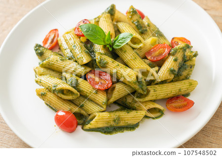 penne pasta with pesto sauce and tomatoes 107548502