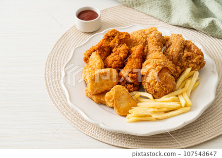 fried chicken with french fries and nuggets on plate 107548647