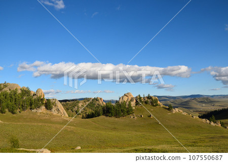 Rocks and clouds floating in the grasslands of Mongolia 107550687