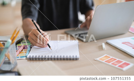 Fashion designer man work to designing clothes and sketching in paper for creative new collection 107551355