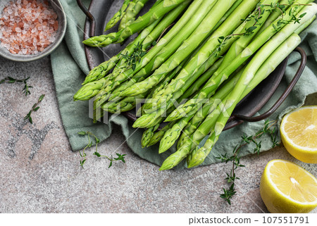 Bunch of raw asparagus stems with different spices 107551791