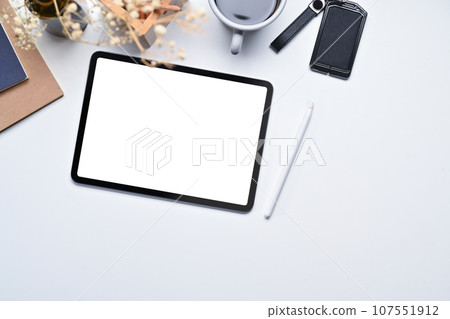 Top view of digital tablet, stylus pen, notebook and coffee cup on white office desk 107551912