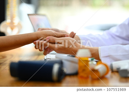 Close up doctor holding hand of elderly patient. Medical care and support concept Close up doctor holding hand of elderly patient. Medical care and support concept 107551989