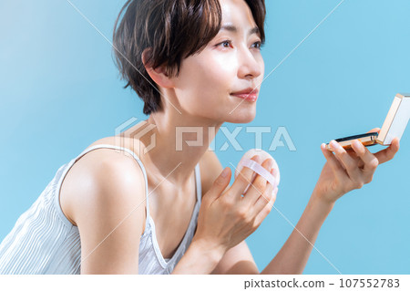 A middle-aged woman taking UV care against a blue background 107552783