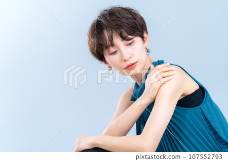 A middle-aged woman doing skin care against a gray background 107552793