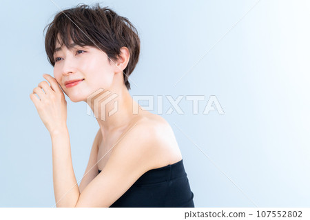 A middle-aged woman doing skin care against a gray background A middle-aged woman doing skin care against a gray background 107552802
