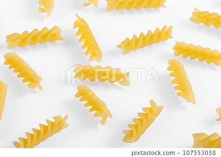Pasta products in the form of a spiral, texture, on a white background Pasta products in the form of a spiral, texture, on a white background 107553038