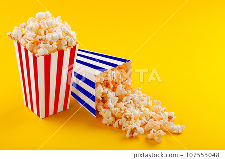 Glass with popcorn on a yellow background Glass with popcorn on a yellow background 107553048