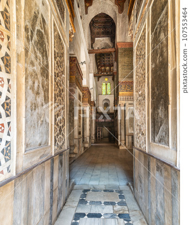 Narrow decorated marble hallway in the Qalawun Complex, with stained glass window at one end, Moez Street, Cairo, Egypt 107553464
