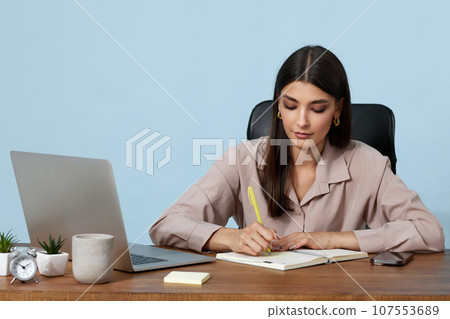beautiful businesswoman in beige shirt taking notes beautiful businesswoman in beige shirt taking notes 107553689