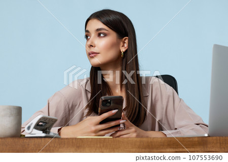 beautiful businesswoman in beige shirt using mobile phone beautiful businesswoman in beige shirt using mobile phone 107553690