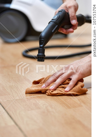 male hand with professional cleaning steam generator cleaning tiled floor 107553704