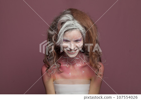 Attractive woman with Halloween makeup laughing on red background 107554026