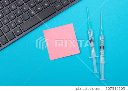 Vaccination or Revaccination Concept - Two Medical Syringe on Blue Table Vaccination or Revaccination Concept - Two Medical Syringe on Blue Table 107554205
