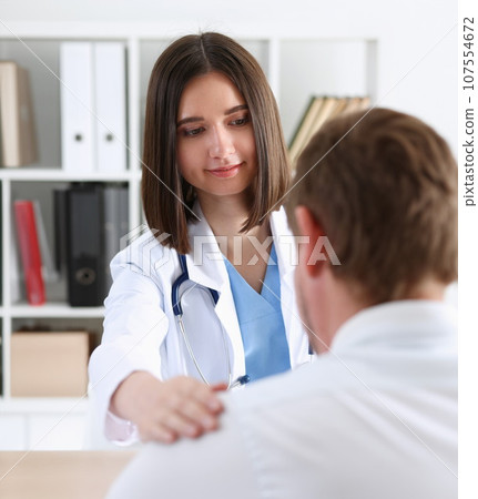 Friendly female doctor hold patient shoulder Friendly female doctor hold patient shoulder 107554672