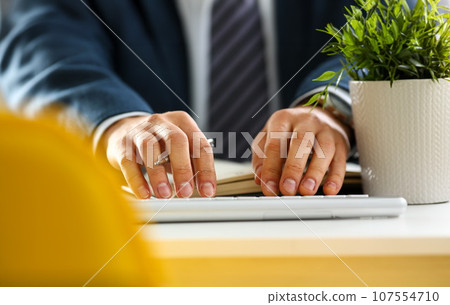 Male arms in suit typing on silver keyboard Male arms in suit typing on silver keyboard 107554710