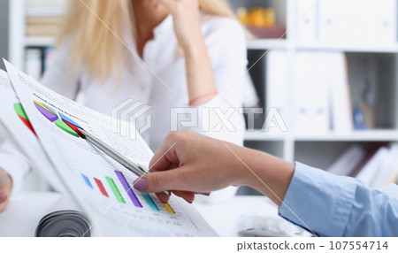 Group of people deliberate on problem with clipboard 107554714