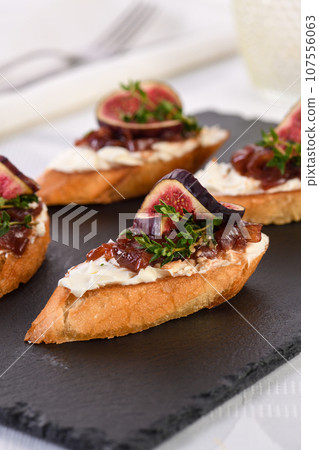 Crostini with onion jam, figs and cheese Crostini with onion jam, figs and cheese 107556063