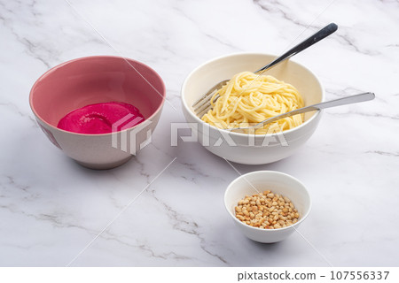 Garlic beetroot sauce, boiled spaghetti or vermicelli and pine nuts. 107556337