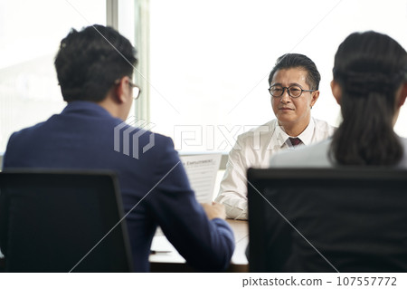 older asian business man job seeker being interviewed by young human resources executives 107557772